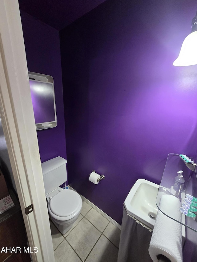 bathroom featuring tile patterned floors, toilet, and baseboards