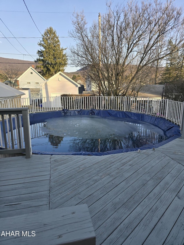 view of swimming pool with a covered pool and a deck