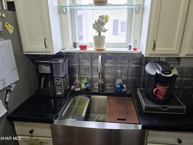 kitchen with dark countertops, decorative backsplash, and white cabinets