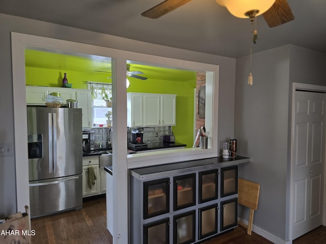 kitchen with dark wood-style floors, stainless steel fridge, white cabinets, and ceiling fan