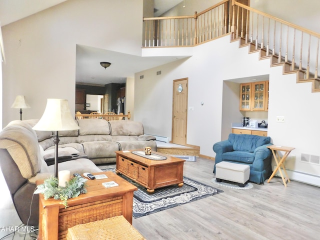 living room with a towering ceiling and light hardwood / wood-style floors