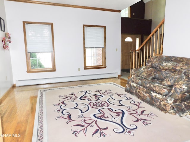 living room featuring hardwood / wood-style floors, a baseboard radiator, and ornamental molding