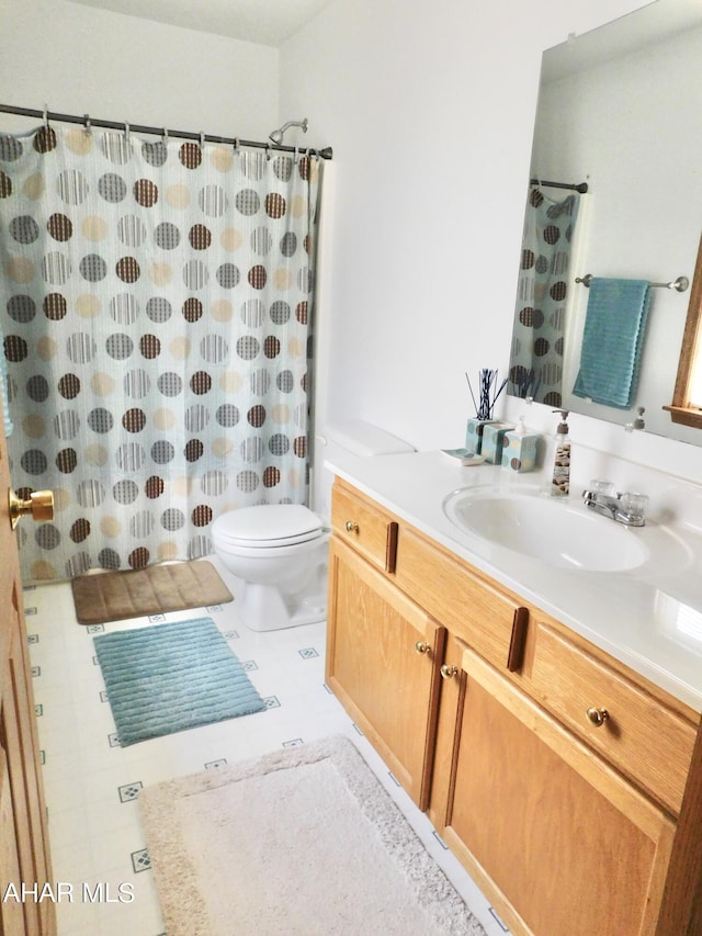 bathroom featuring tile patterned floors, vanity, and toilet