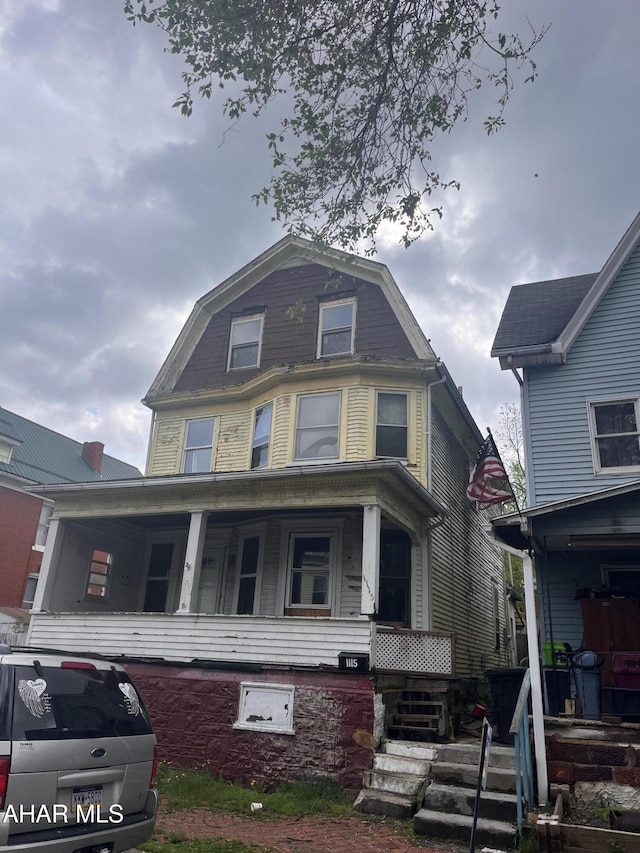 dutch colonial featuring a gambrel roof and a porch