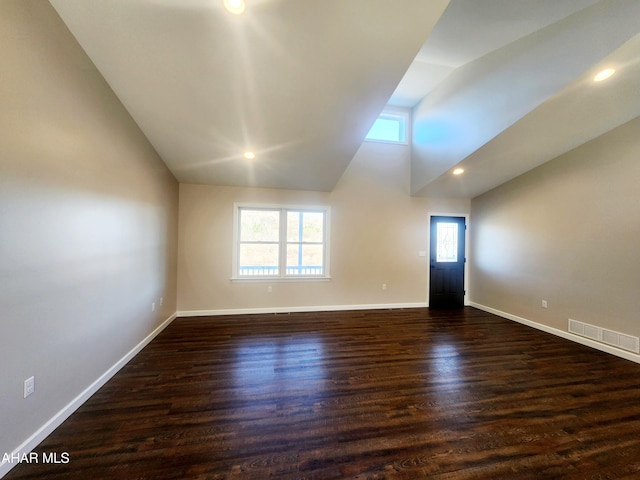 empty room with lofted ceiling and dark wood-type flooring