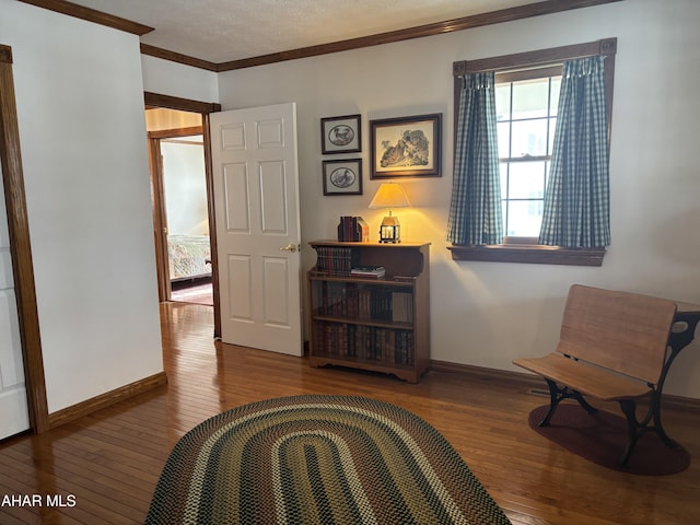 living area with hardwood / wood-style floors and ornamental molding