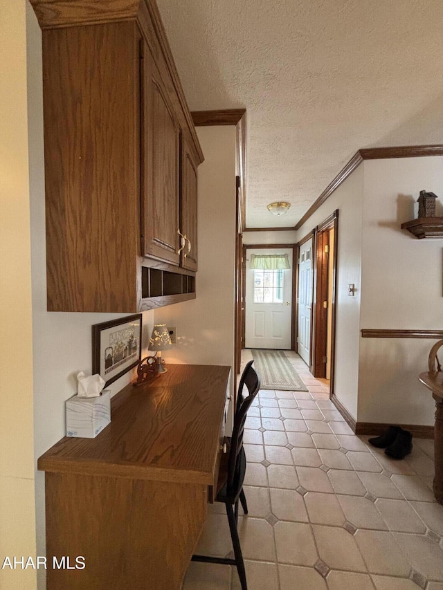 corridor featuring a textured ceiling and crown molding