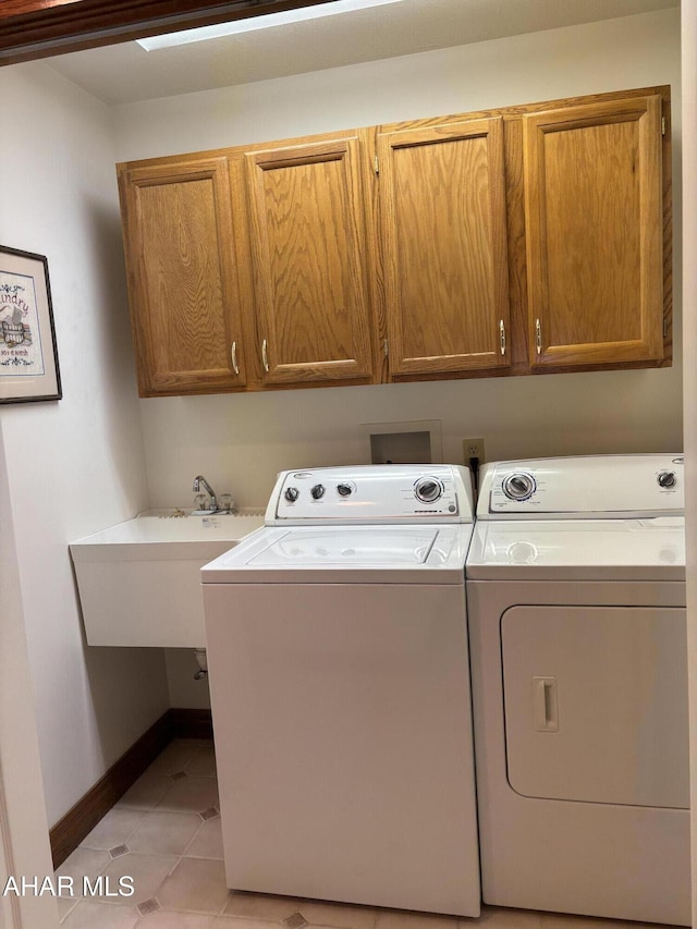 washroom with cabinets, independent washer and dryer, sink, and light tile patterned floors