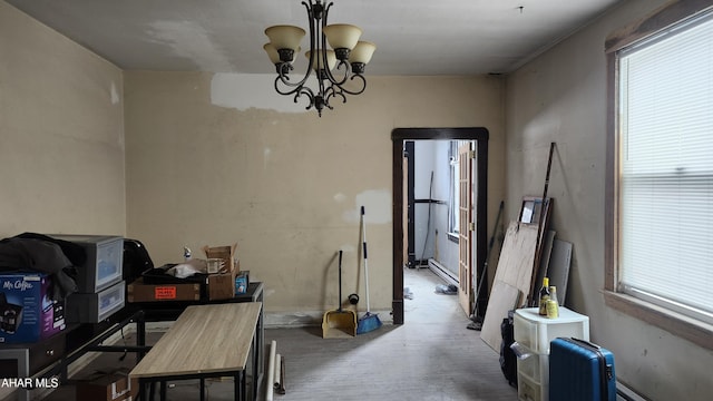 dining space with wood finished floors, a baseboard radiator, baseboard heating, and a chandelier