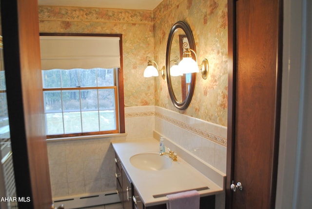 bathroom with tile walls, a baseboard radiator, vanity, and wallpapered walls