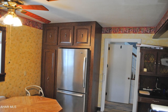 kitchen with ceiling fan, freestanding refrigerator, and wallpapered walls