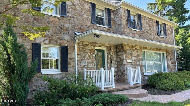 view of front of property featuring stone siding and covered porch