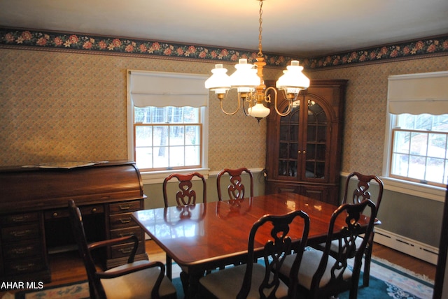 dining area featuring wallpapered walls, a baseboard heating unit, and an inviting chandelier