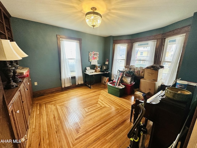 misc room with an inviting chandelier, a wealth of natural light, and light parquet flooring