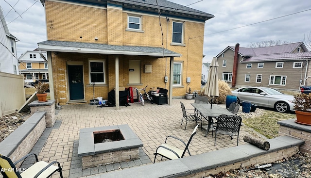 rear view of house featuring a patio and an outdoor fire pit