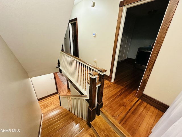 staircase with hardwood / wood-style flooring