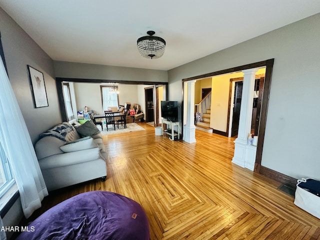 living room featuring parquet flooring and decorative columns