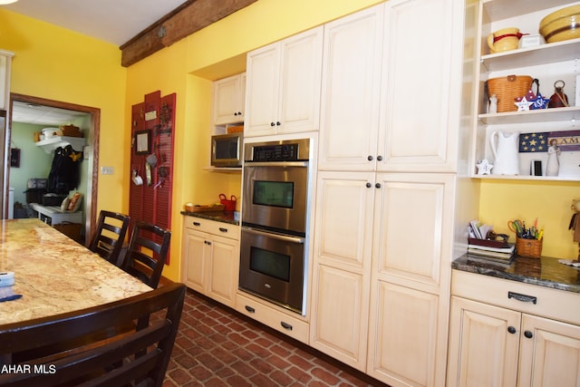 kitchen featuring stainless steel appliances and dark stone counters