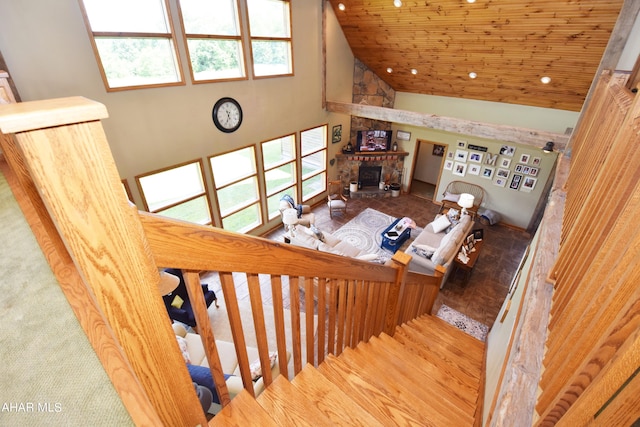 stairway featuring a fireplace and high vaulted ceiling