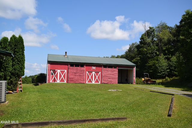 view of outbuilding with a yard and central AC unit