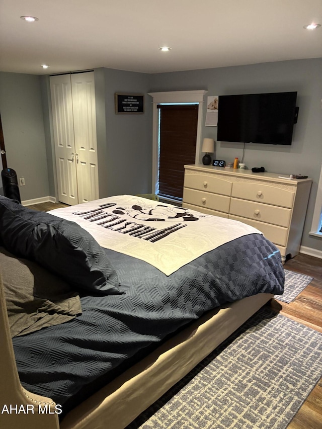 bedroom with wood-type flooring and a closet