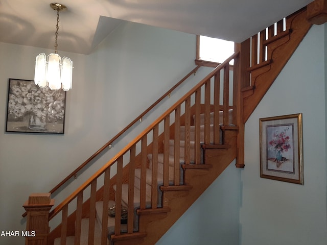 stairs featuring a chandelier