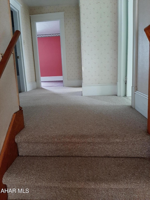 interior space with wallpapered walls, stairway, and carpet flooring