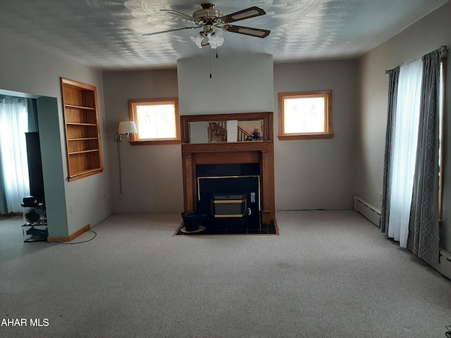 unfurnished living room featuring a ceiling fan, carpet flooring, plenty of natural light, and baseboard heating