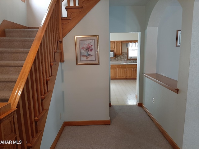 interior space with arched walkways, baseboards, and carpet