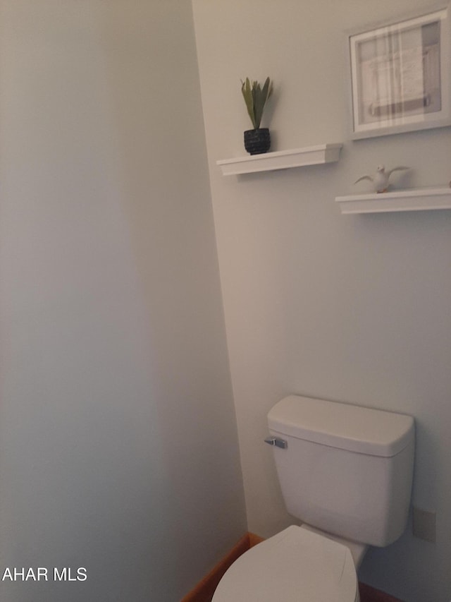 bathroom with toilet and baseboards