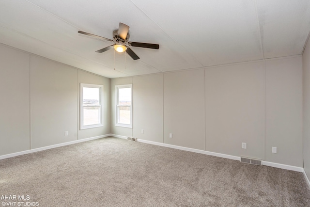 carpeted spare room featuring ceiling fan and lofted ceiling