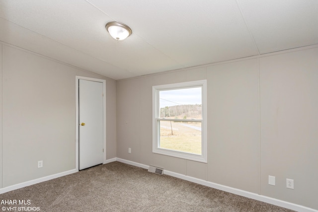 carpeted spare room with lofted ceiling