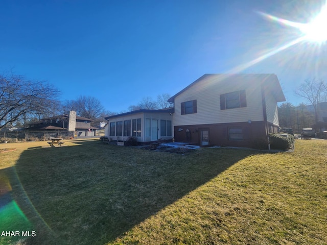 back of house with a yard and a sunroom