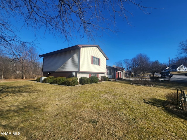 view of home's exterior with a yard and brick siding