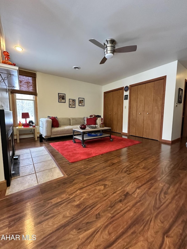 living room featuring ceiling fan and dark hardwood / wood-style flooring