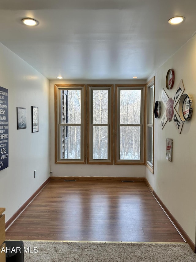 unfurnished room with plenty of natural light and dark wood-type flooring