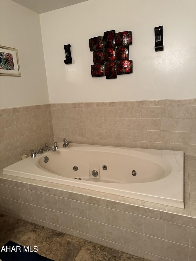 bathroom with a relaxing tiled tub and tile patterned flooring