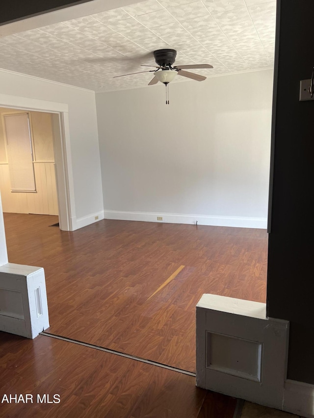 empty room with ceiling fan, wood-type flooring, and a textured ceiling