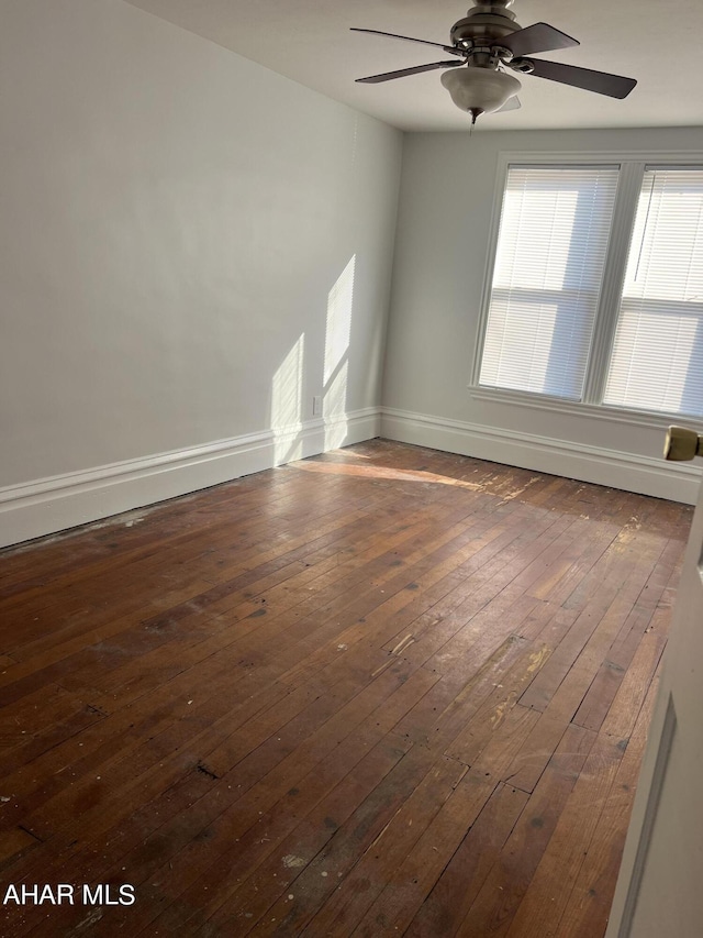 unfurnished room with ceiling fan and dark wood-type flooring