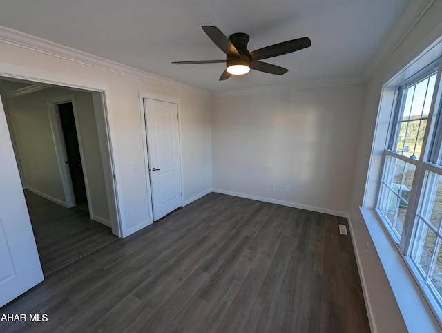 unfurnished bedroom featuring crown molding, dark wood-type flooring, and ceiling fan