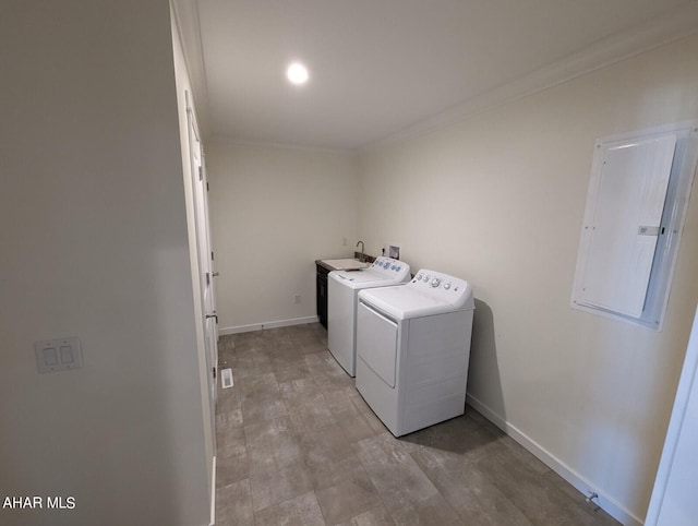 clothes washing area featuring washing machine and clothes dryer, ornamental molding, and electric panel