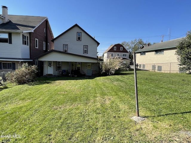 rear view of property featuring a yard