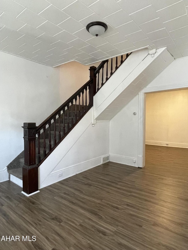 stairs with vaulted ceiling and hardwood / wood-style flooring