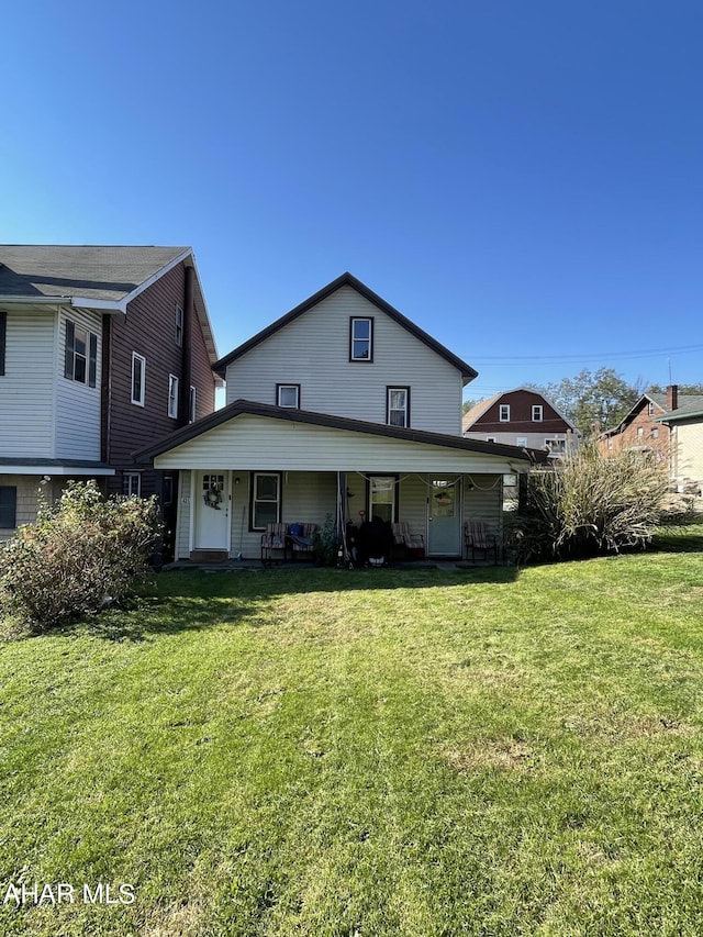 back of property featuring a lawn and covered porch