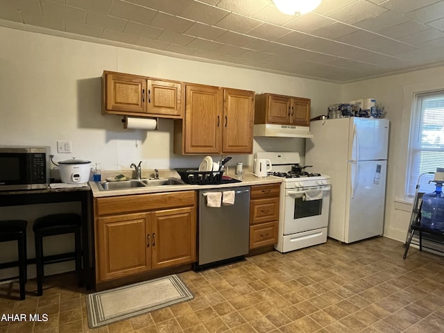 kitchen with appliances with stainless steel finishes, ornamental molding, and sink