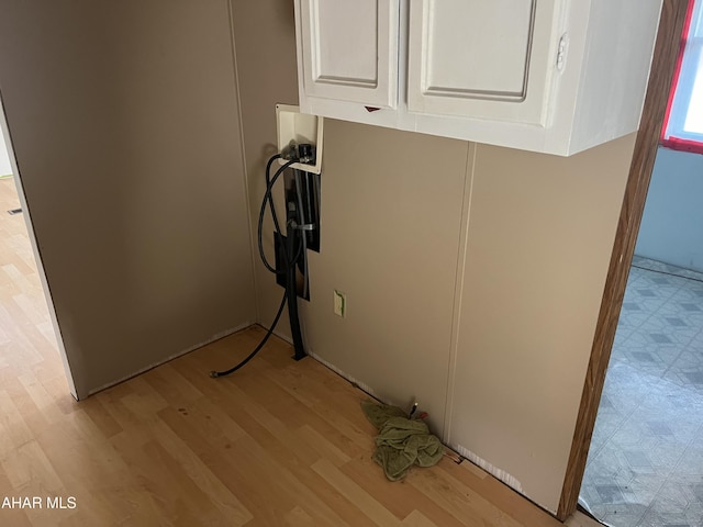 washroom featuring cabinets, hookup for a washing machine, and light hardwood / wood-style flooring