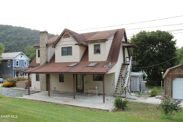 back of house with a patio area and a yard