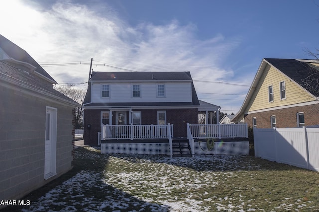 snow covered rear of property with covered porch