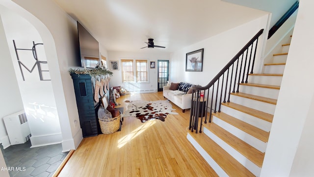 foyer entrance with radiator heating unit, ceiling fan, and hardwood / wood-style floors