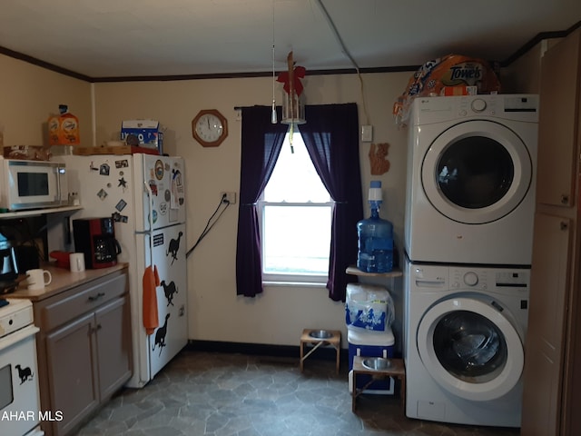 laundry room featuring crown molding and stacked washer and dryer